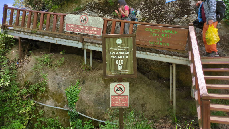 Bir tabiat parkında dör ayrı igreti dikilmiş yasak levhası. Av, tırmanış, kamp ve gölete girmek yasakmış